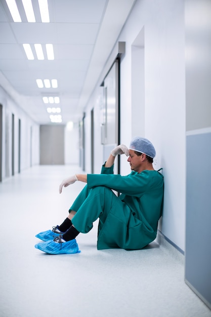 Chirurgien de sexe masculin assis dans le couloir