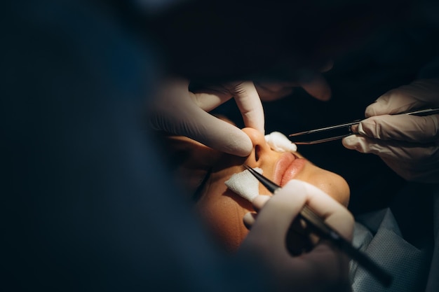 Chirurgien et son assistant effectuant une chirurgie esthétique sur le nez dans la salle d'opération de l'hôpital Rhinoplastie d'augmentation du remodelage du nez