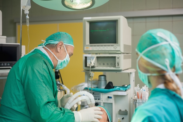 Photo chirurgien tenant un masque sur le visage d'un patient