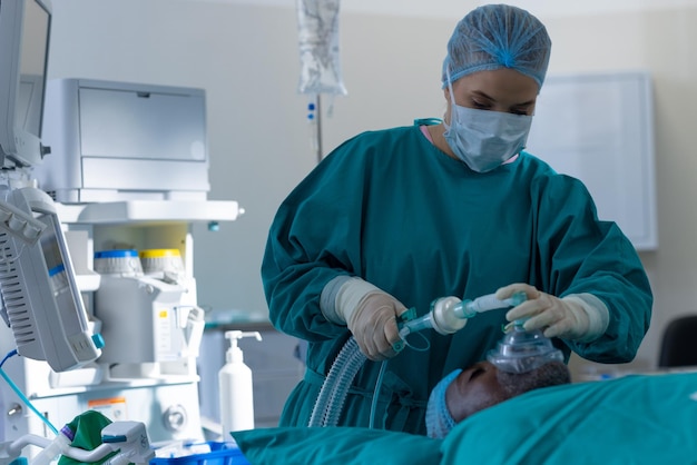 Photo chirurgienne caucasienne mettant un masque facial anesthésique sur un patient en salle d'opération à l'hôpital