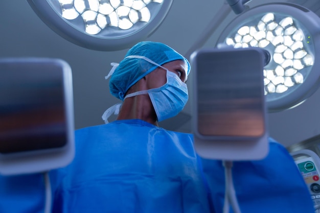 Photo une chirurgienne utilisant un défibrillateur dans la salle d'opération d'un hôpital