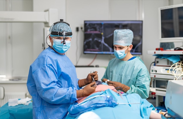 Chirurgiens professionnels travaillant dur dans une chambre d'hôpital moderne. De beaux chirurgiens travaillant dans un service hospitalier d'urgence.