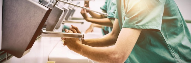 Les chirurgiens se lavent les mains à l'hôpital en souriant