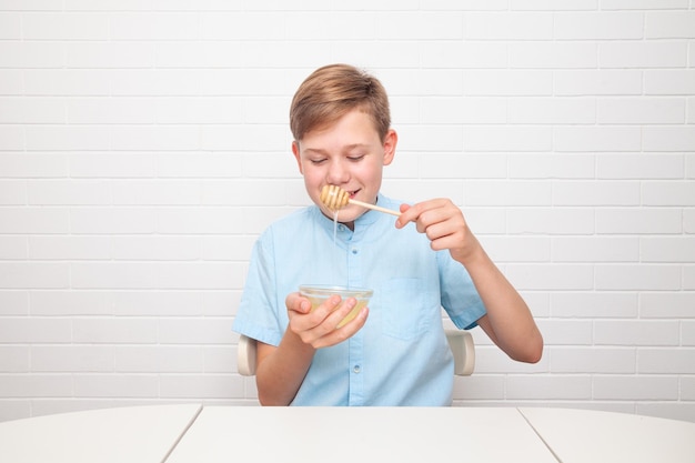 Chisinau, MOLDOVA - 29 juin 2022. Un adolescent européen goûte du miel