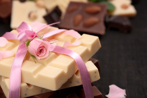 Chocolat attaché avec un ruban rose sur un mur noir