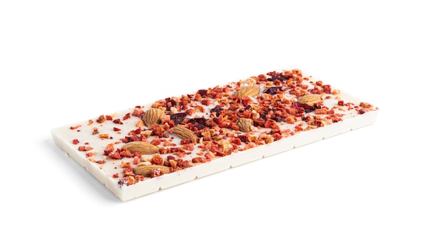Chocolat blanc aux amandes, canneberges et tranches de fraise isolé sur une surface blanche