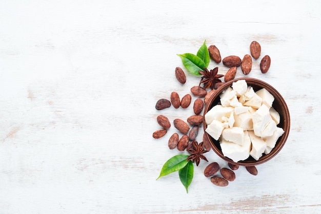 Chocolat blanc et fèves de cacao. Sur un fond blanc. Vue de dessus. Espace de copie gratuit.