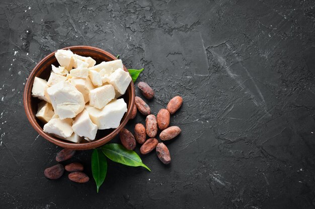 Chocolat blanc et fèves de cacao Sur fond noir Vue de dessus Espace de copie gratuit