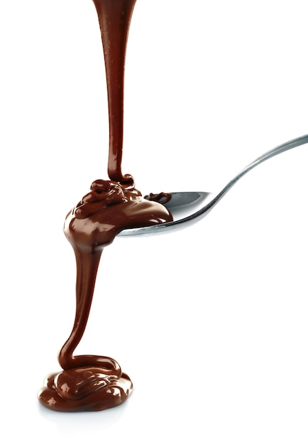 Chocolat brun laiteux fondu versant d'une cuillère isolée sur blanc