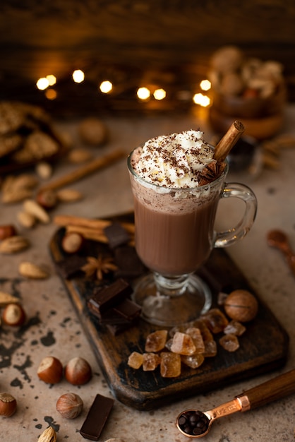 Chocolat chaud au cacao avec crème fouettée et chocolat râpé dans une tasse en verre