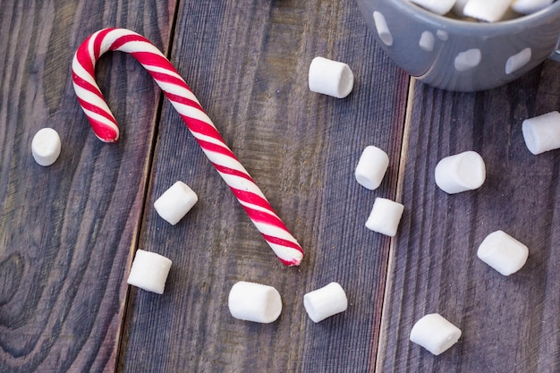 Photo chocolat chaud au café avec de la guimauve sur fond de table en bois rustique, boîtes de cadeau de bonbons cannes sapin