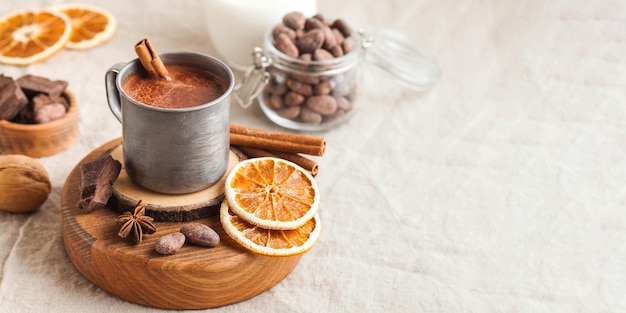 Chocolat chaud de bannière dans une tasse en métal avec un bâton de cannelle sur l'espace de copie de nappe