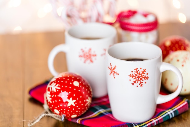 Chocolat chaud dans des tasses blanches avec des flocons de neige rouges.