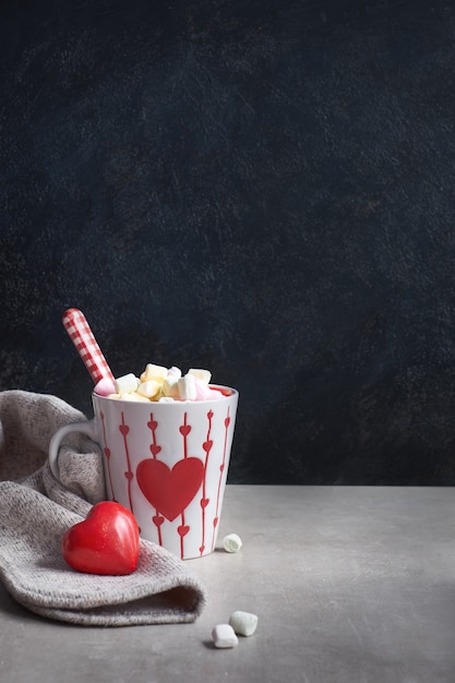 Chocolat chaud avec des guimauves, coeur rouge sur la tasse sur la table