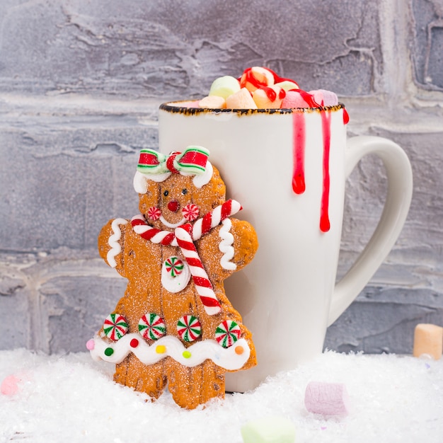 Photo chocolat chaud avec jouet de biscuit de fille de pain d'épice de guimauves et de pain d'épice sur le fond blanc de noël
