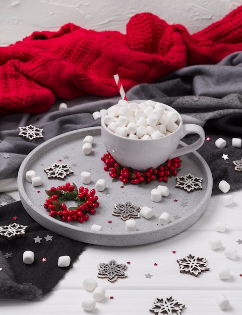 Chocolat chaud de Noël ou café à la guimauve sur une table en bois blanche avec des décorations de Noël