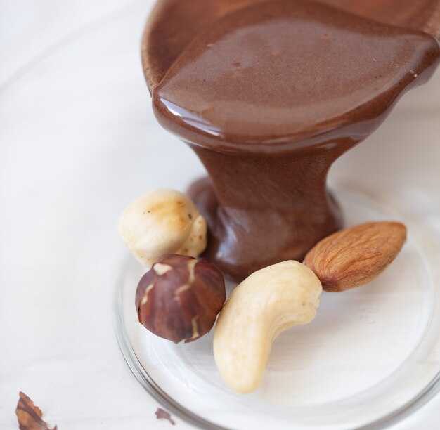 Chocolat fondu chaud versant sur des écrous