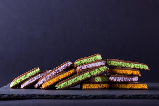 Chocolat avec garniture de fruits sur fond noir tranches de chocolat avec baies bleues menthe