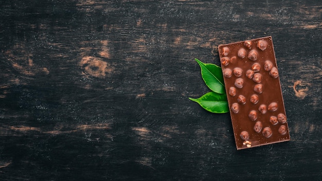 Photo chocolat noir aux noisettes cacao sur un fond en bois vue de dessus copiez l'espace pour le texte