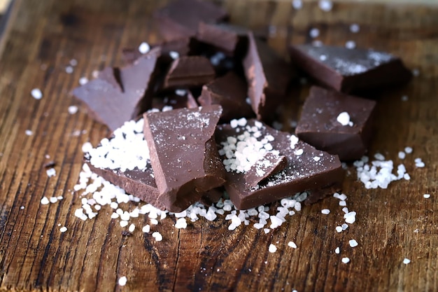 Photo chocolat noir avec du sel sur une surface en bois