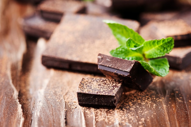 Chocolat noir et menthe verte sur la table en bois