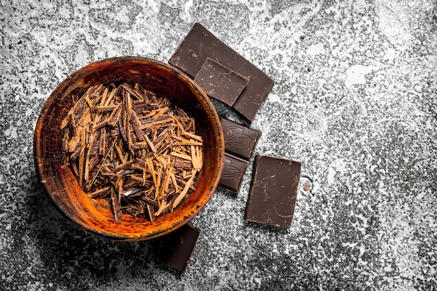 Chocolat râpé dans un bol. Sur un fond rustique.