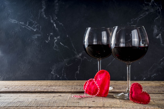 Chocolat, roses, verres à vin et boîte coeur sur table en bois