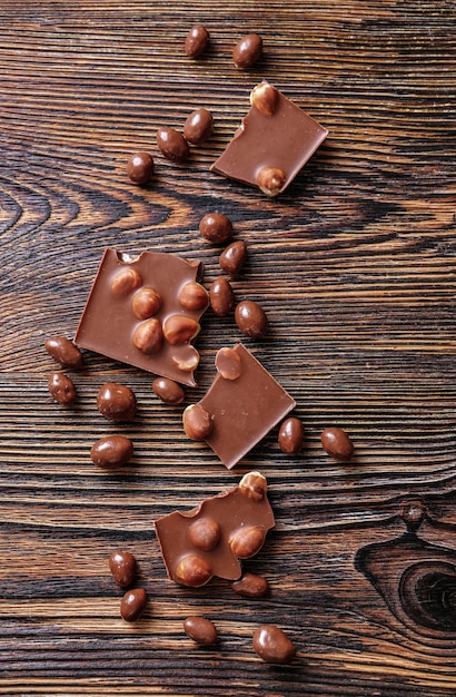Chocolat savoureux aux noisettes sur table en bois