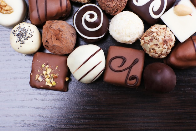 Chocolats assortis sur le fond lisse en bois foncé