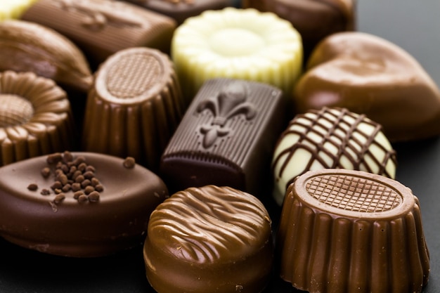 Chocolats assortis sur fond noir.