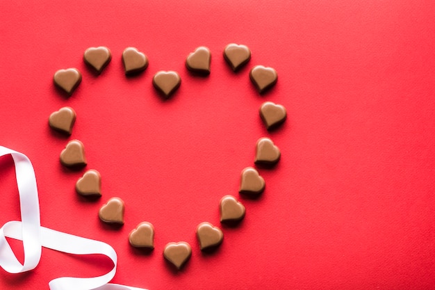 Chocolats en forme de coeur sur fond rouge pour la Saint Valentin