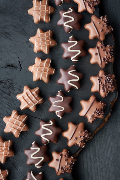 Des chocolats en forme d'étoile sur du bois foncé