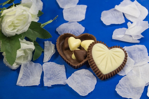 chocolats avec des formes de coeur et des roses blanches pour la célébration de la journée blanche