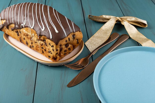 Chocotone avec enrobage de chocolat à côté de l'arc de ruban de couverts et de la vue de l'assiette