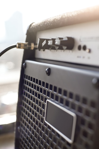 Choisir un ampli guitare. Vue rapprochée verticale de l'amplificateur de guitare avec prise audio par câble. Instruments de musique. Équipement de musique