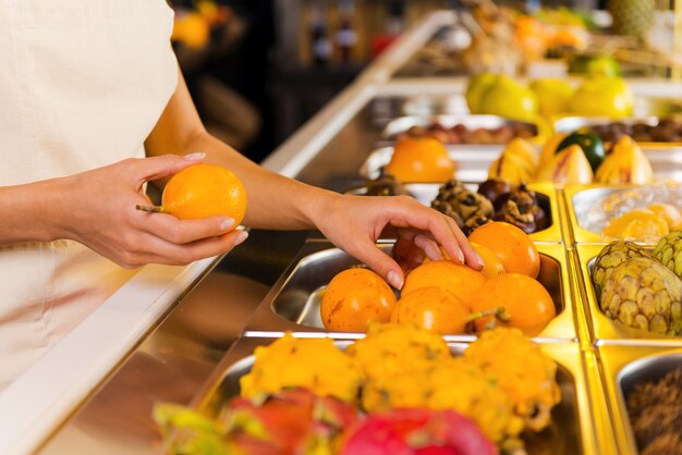 Choisir les fruits les plus frais. Gros plan sur une femme choisissant des fruits dans une épicerie