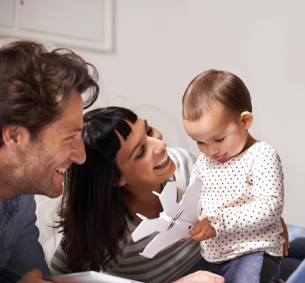 Choisir les jouets plutôt que la technologie Photo d'une mère et d'un père heureux qui passent du temps de qualité avec leur petite fille