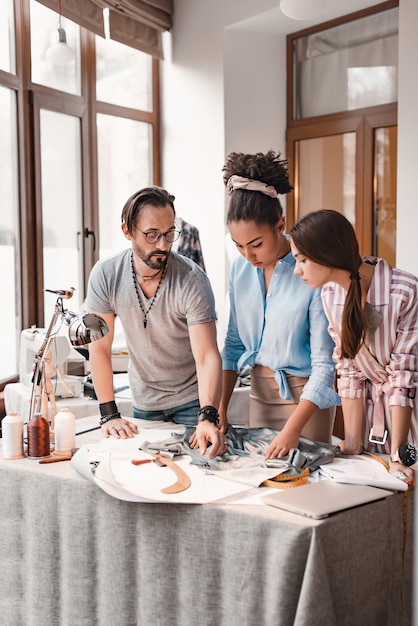 Photo choisir un matériau parfait. groupe de trois personnes au studio de design. l'homme et deux femmes font decigion