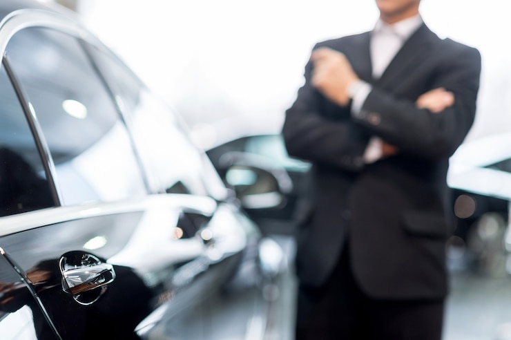 Photo choisir une voiture en concession. gentil homme aux cheveux gris en tenue de soirée se penchant sur la voiture et détournant les yeux