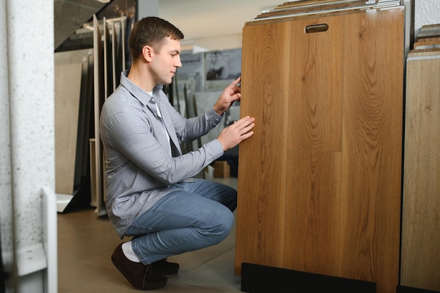 Le choix du parquet L'homme est dans le magasin de biens pour la maison