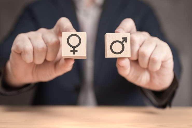Photo le choix entre les mains de l'homme et de la femme tient deux cubes en bois avec un signe masculin et féminin