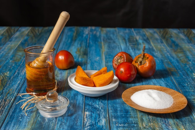 Chontaduro, fruit tropical exotique, coupé avec du sel et du miel à côté de chontaduros crus sur une table en bois bleu rustique. Bactris gasipes