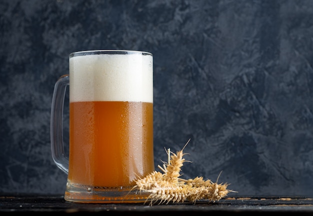 Chope de bière de blé non filtrée sur le fond d'un mur de béton dans le pub avec espace de copie