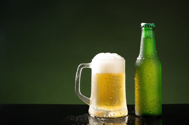 Chope de bière et bouteille sur fond vert avec fond.