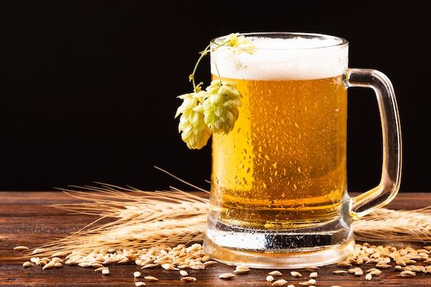 Photo chope de bière avec du houblon sur une planche de bois