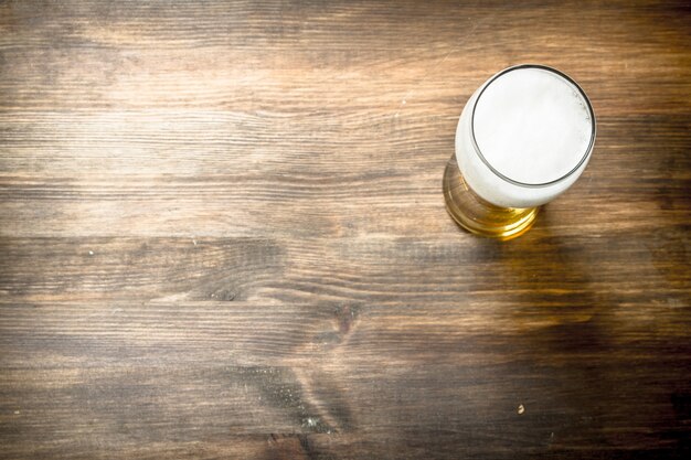 Chope de bière fraîche. Sur une table en bois.