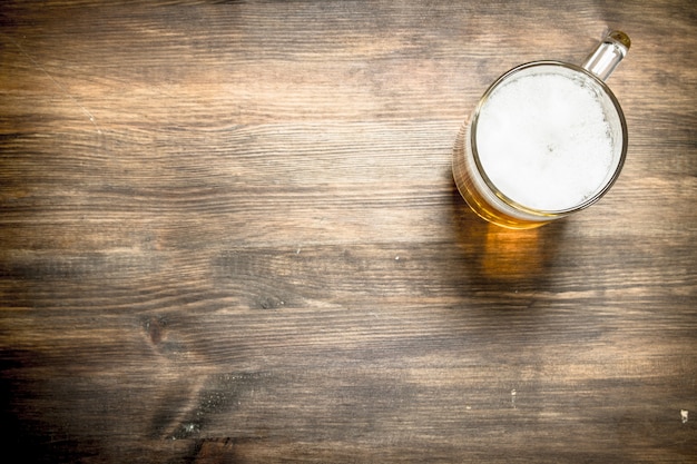 Chope de bière fraîche sur une table en bois