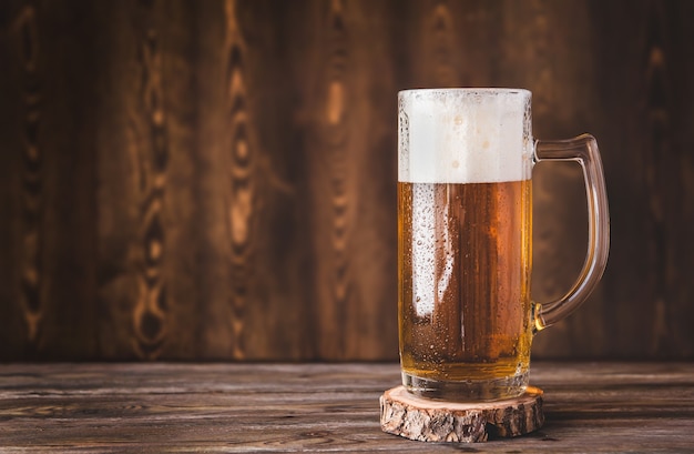 Chope de bière avec de la mousse sur une table en bois