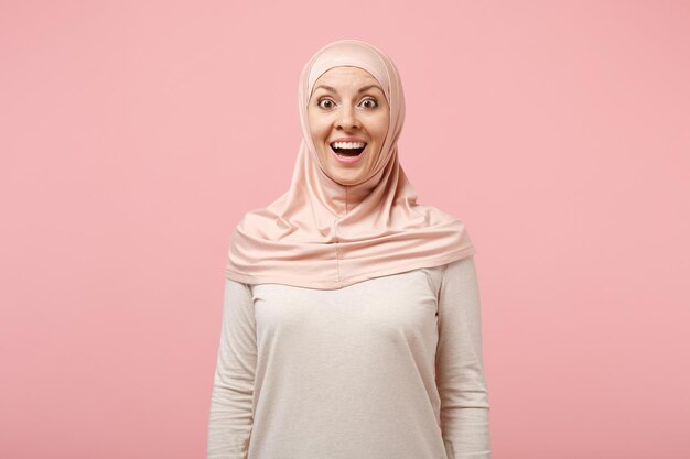Choqué excité jeune femme musulmane arabe en vêtements légers hijab posant isolé sur fond rose portrait en studio. Concept de style de vie de l'islam religieux des gens. Maquette de l'espace de copie. Garder la bouche ouverte.