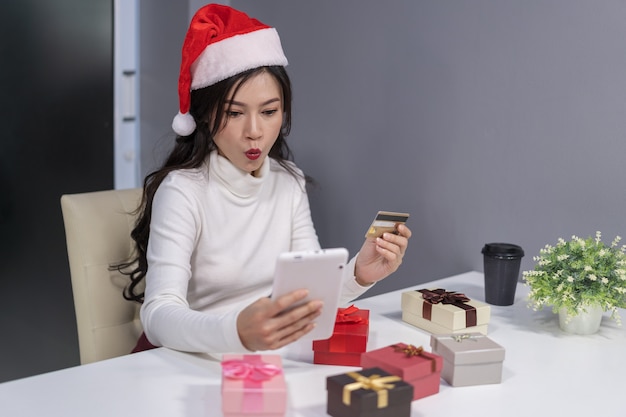 Choqué, femme, dans, santa hat, achats en ligne, pour, cadeau noël, à, tablette numérique